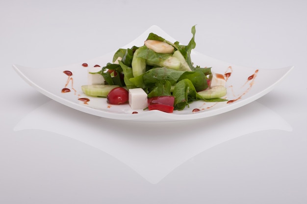 Salade dans une assiette blanche sur fond blanc