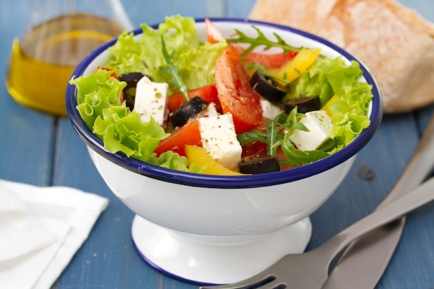 Salade dans un bol avec du pain et de l'huile