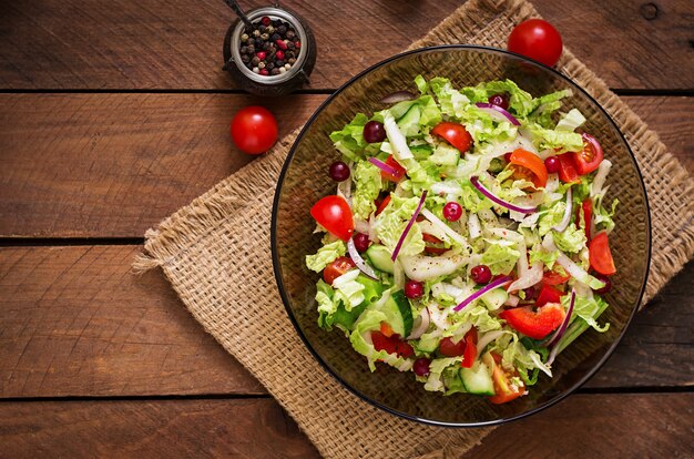 Salade diététique aux légumes frais (tomate, concombre, chou chinois, oignon rouge et canneberges). Vue de dessus