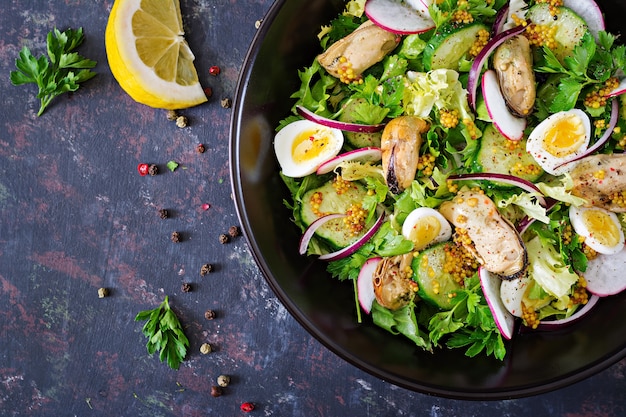 Salade diététique aux moules, œufs de caille, concombres, radis et laitue. Nourriture saine. Salade de fruit de mer. Vue de dessus. Mise à plat.