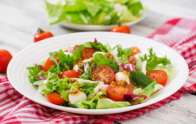 Salade diététique aux tomates, laitue mozzarella avec vinaigrette miel-moutarde