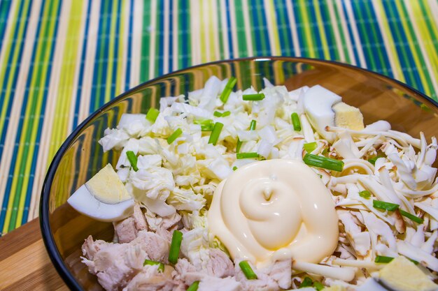 Salade diététique pour une bonne nutrition avec du poulet et des œufs sur un tapis vert.