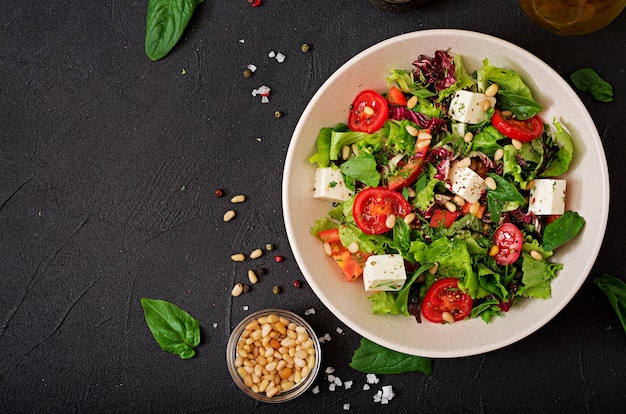 Salade diététique avec tomates, feta, laitue, épinards et pignons.