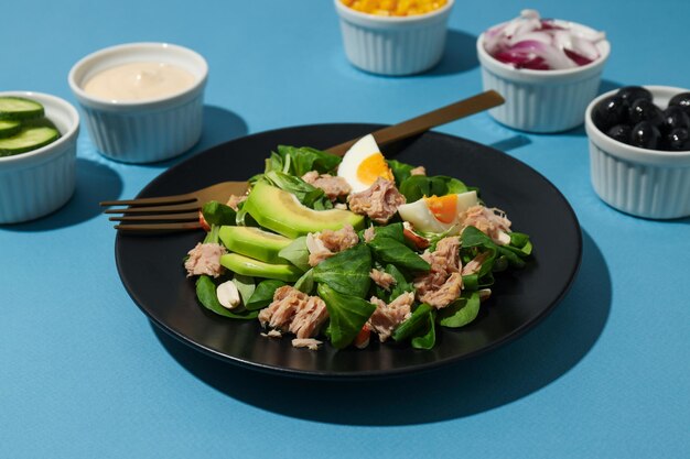 Salade avec du thon sur fond bleu