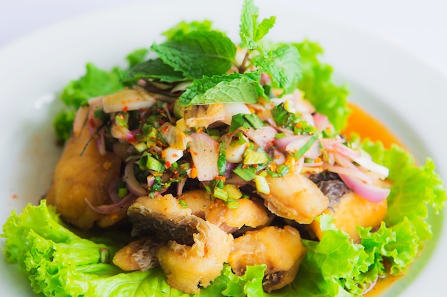 Salade épicée de poisson-chat avec des herbes en fête