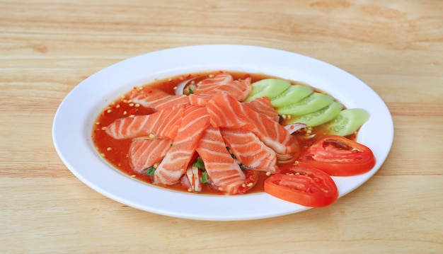 Salade épicée de saumon dans un plat sur fond de table en bois