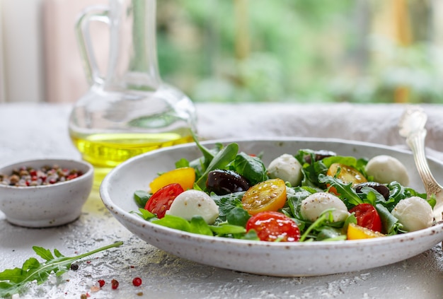 Salade d'été fraîche à la roquette, tomates cerises jaunes et rouges, olives Kalamata et mozzarella