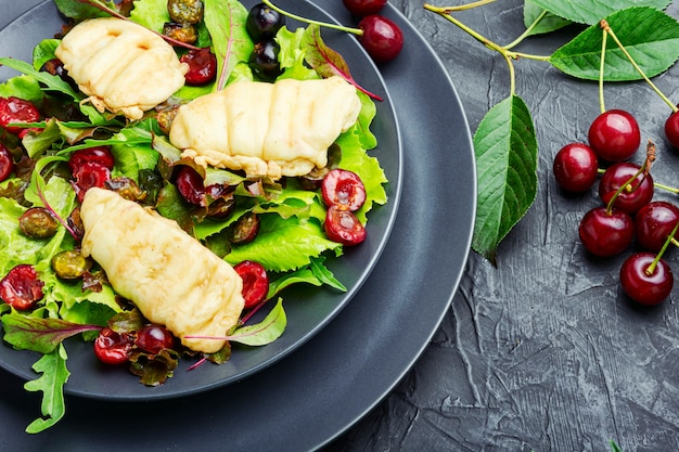 Salade d'été de laitue frisée, fromage halloumi frit et baies de cerise