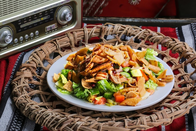 Salade fatoosh fatoosh avec craquelins concombre tomate oignon servi dans un plat isolé sur un tapis rouge vue de dessus sur la table de la nourriture arabe