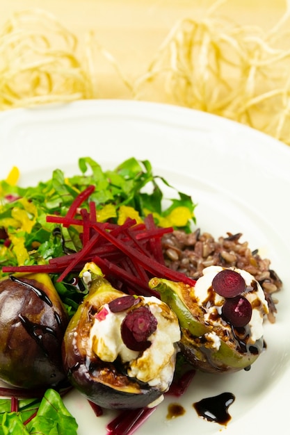 Salade de figues au fromage de chèvre et betteraves, sur une assiette blanche