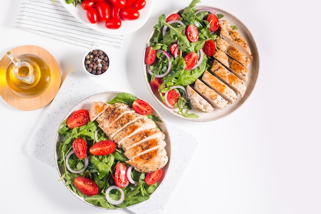 Salade avec filet de poulet grillé, légumes frais, épinards, roquette, oignon rouge et tomate.