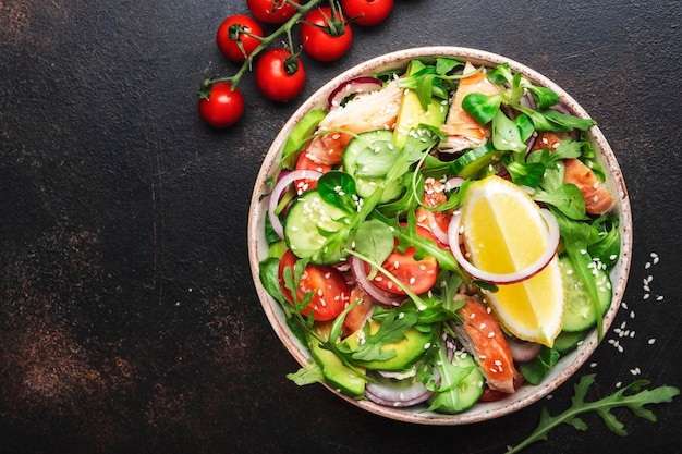 Salade fraîche au poulet tomates roquette avocat avocat graines de sésame et vinaigrette à l'huile de citron Alimentation saine Vue de dessus Table brune