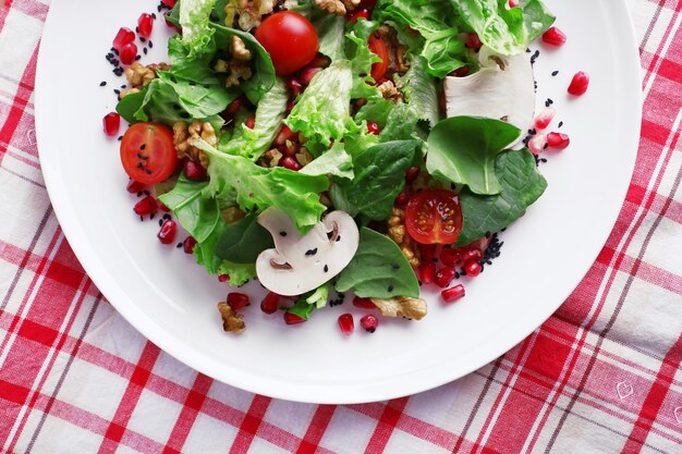 Salade fraîche aux verts grenat et épices sur assiette sur table libre