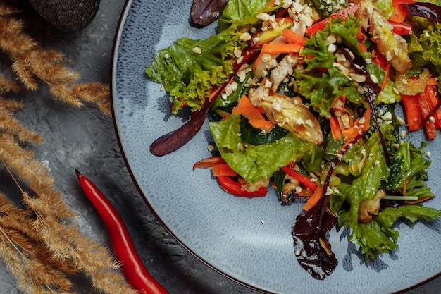 Salade fraîche biologique saine avec tomates, poivrons et poulet Masala. Poitrines de poulet grillées et légumes frais en assiette.