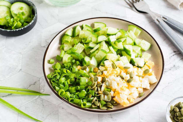 Salade fraîche de concombre œuf à la coque et oignon vert sur une assiette sur la table Gros plan sur le régime cétogène