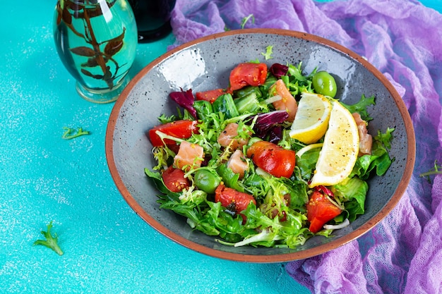 Salade fraîche avec du poisson saumon mélangé avec des verts tomate olives moutarde et jus de citron