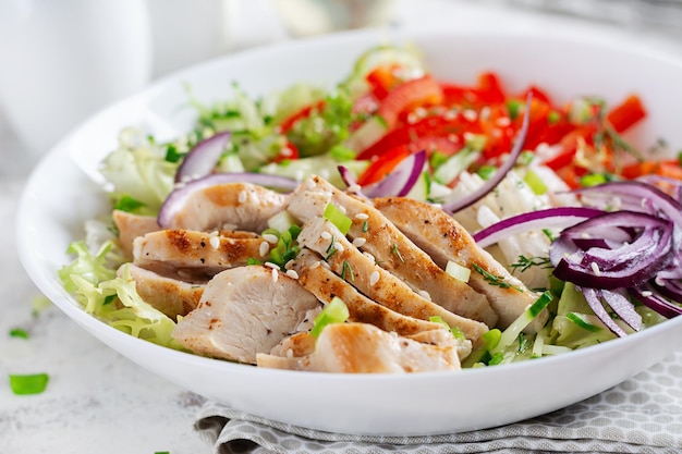 Salade fraîche avec filet de poitrine de poulet grillé et laitue daikon oignons rouges concombre et sésame menu de déjeuner sain nourriture diététique