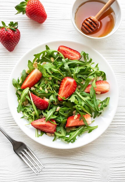 Salade fraîche de fraises et de rogues avec des noix de pin servie par une belle journée