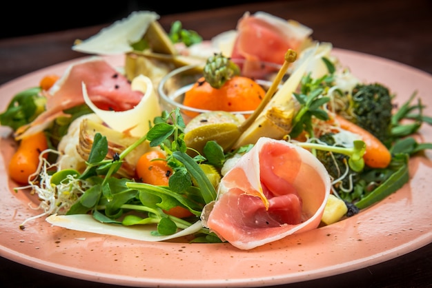 Salade fraîche de légumes, fromage et jambon, sur une assiette colorée