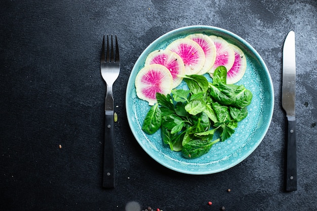 salade fraîche Radis pastèque Daikon chinois Tranches de fruits roses, feuilles vertes, épinards, laitue