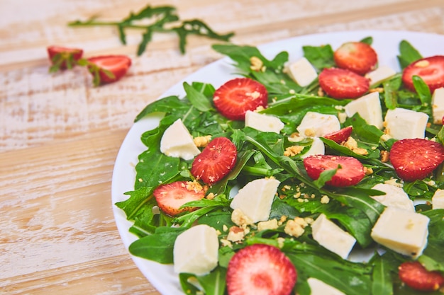 Salade fraîche de roquette, fraises, fromage feta et noix.