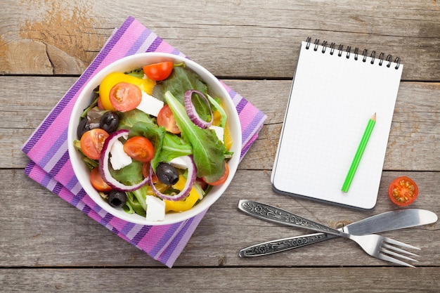 Salade fraîche et saine et bloc-notes pour l'espace de copie