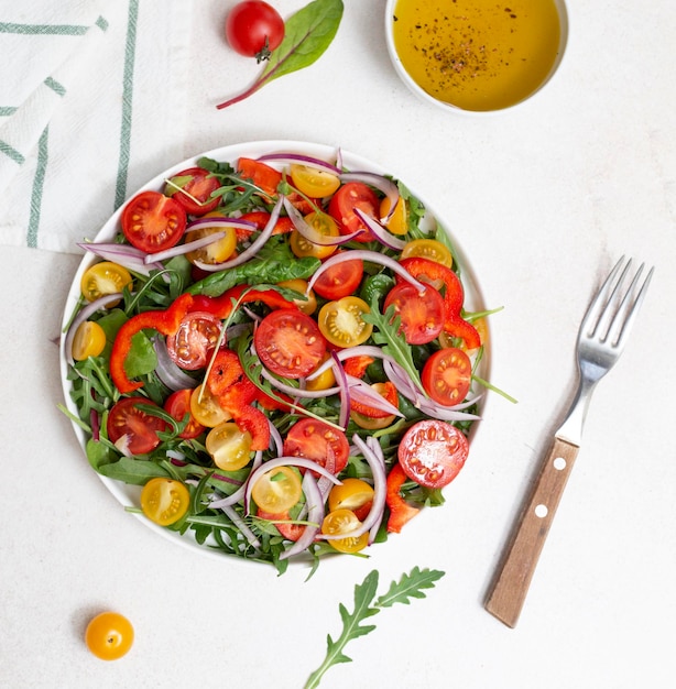 Photo salade fraîche de tomates roquette et poivrons sur fond clair