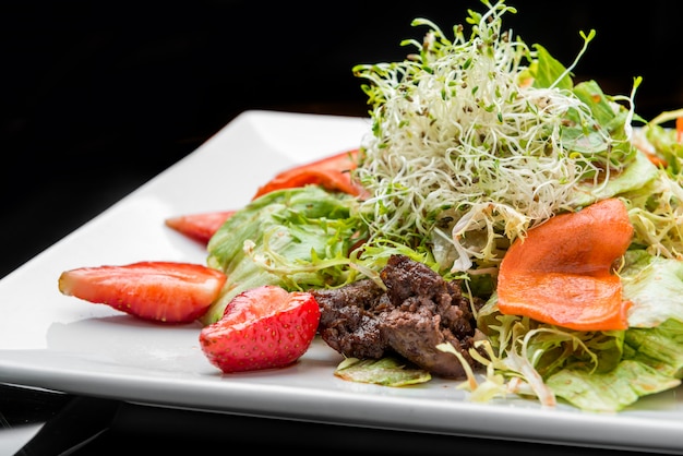 Salade de fraise, avocat, laitue aux noix de cajou sur plaque