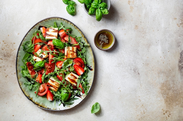 Salade de fraises, tomates, roquette et fromage halloumi