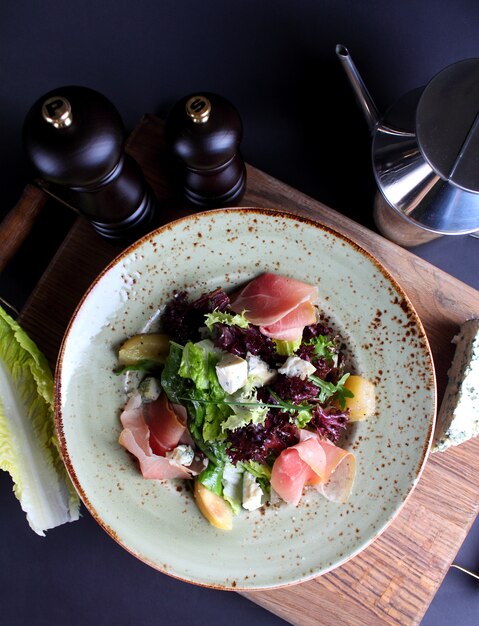 Salade de fromage au jambon vert séché dans une assiette vintage