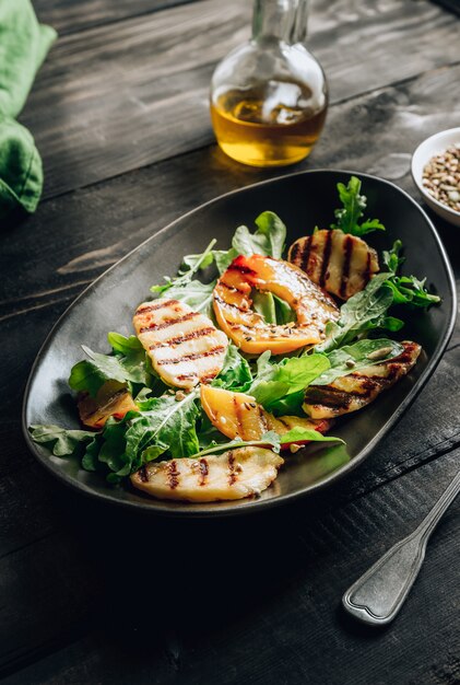 Salade de fromage Halloumi grillé à la pêche et à la roquette.