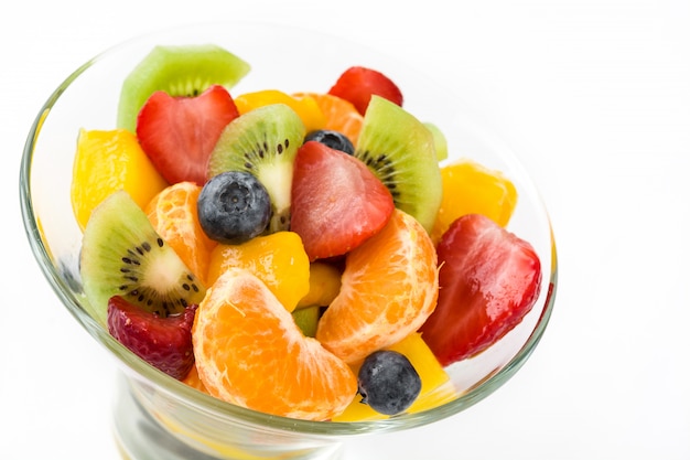 Salade de fruits dans un bol en cristal isolé sur blanc