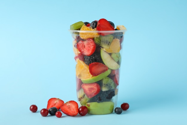 Salade de fruits dans une tasse à emporter sur bleu