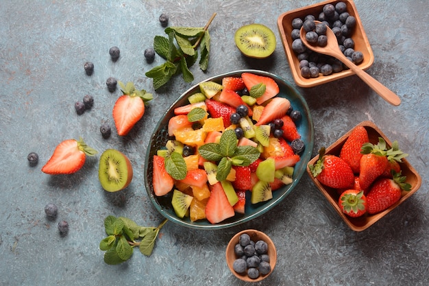 Salade de fruits d'été aux oranges, fraises, myrtilles, kiwi et menthe fraîche