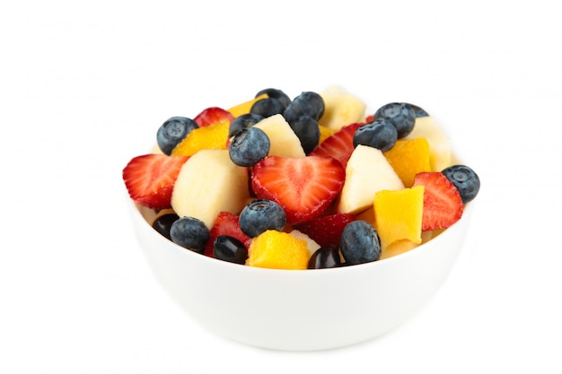 Salade de fruits frais dans un bol blanc isolé sur fond blanc