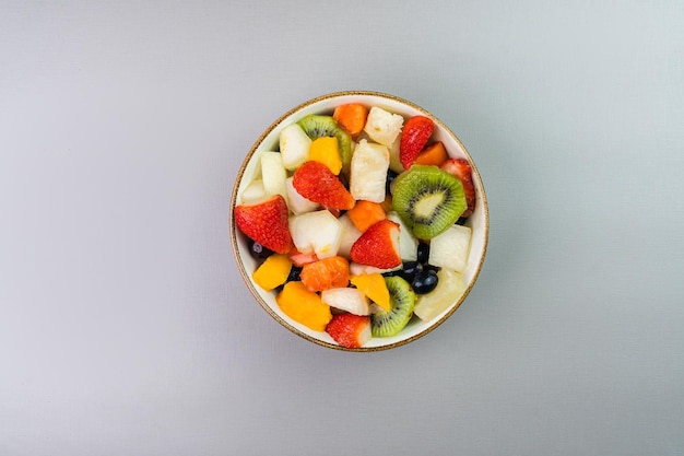 Salade de fruits frais dans un bol Fruits multicolores et tropicaux Ananas mangue raisin fraise papaye melon kiwi Vue de dessus Mise au point sélective