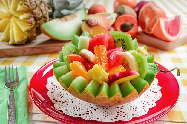 Salade de fruits frais avec kiwi banane pêche orange rouge orange abricot et melon dans un bol de melon