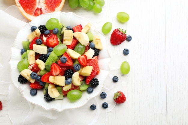 Salade de fruits frais sur une table en bois blanche