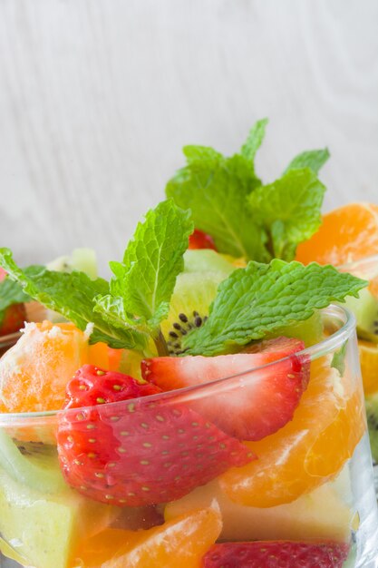 Salade de fruits frais en verre sur table en bois