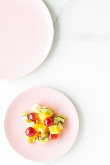 Salade de fruits juteuse pour le petit-déjeuner sur un régime plat en marbre et un concept de mode de vie sain