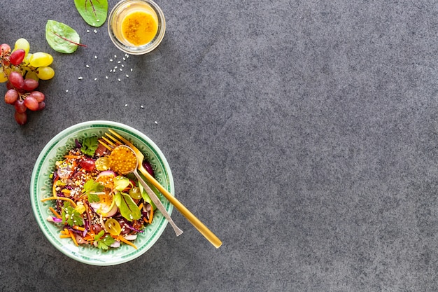 Salade de fruits et légumes frais dans une assiette sur pierre noire. Vue de dessus