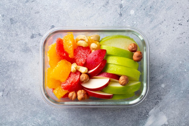 Salade de fruits et noix dans un récipient en verre Alimentation saine Fond gris Vue de dessus