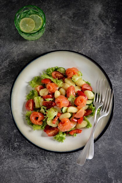 Salade de gnocchi de pommes de terre avec tomates, concombre, poivron, saumon et laitue