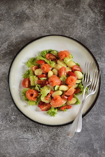 Salade de gnocchi de pommes de terre avec tomates, concombre, poivron, saumon et laitue