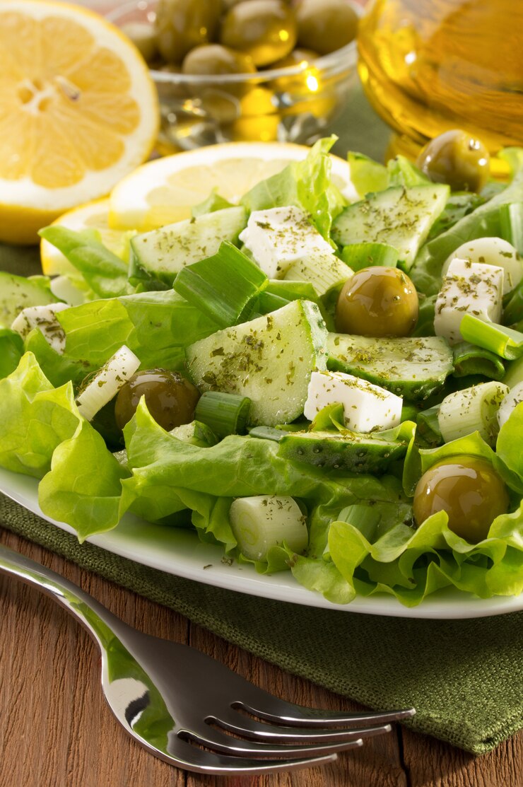 Photo salade grecque en assiette près d'huile d'olive et de citrons