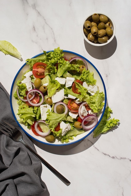 Salade grecque aux légumes et fromage sur une table grise