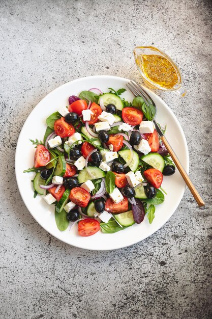 Salade grecque de concombre frais tomate oignon rouge fromage feta et olives à l'huile d'olive Salade de légumes et de légumes verts Vue de dessus d'aliments sains