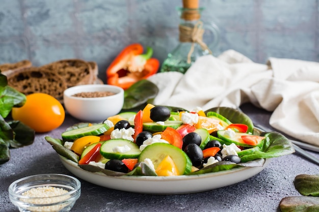 Salade grecque de feuilles de légumes frais et de feta sur une assiette sur la table