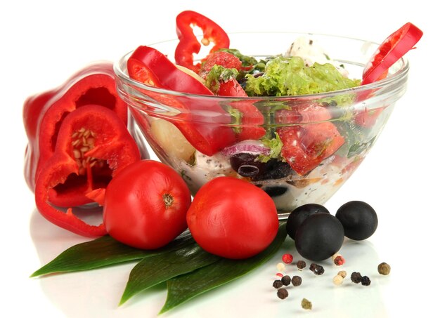 Salade grecque fraîche dans un bol en verre isolé sur blanc