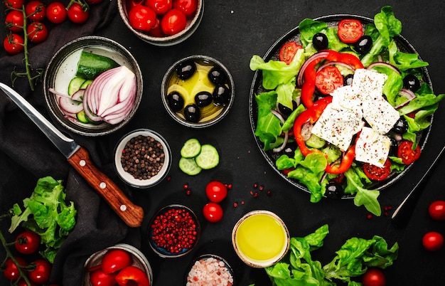 Salade grecque avec fromage feta olives tomate cerise paprika concombre et oignon rouge régime végétarien méditerranéen sain aliments faibles en calories manger fond de pierre noire vue de dessus espace de copie